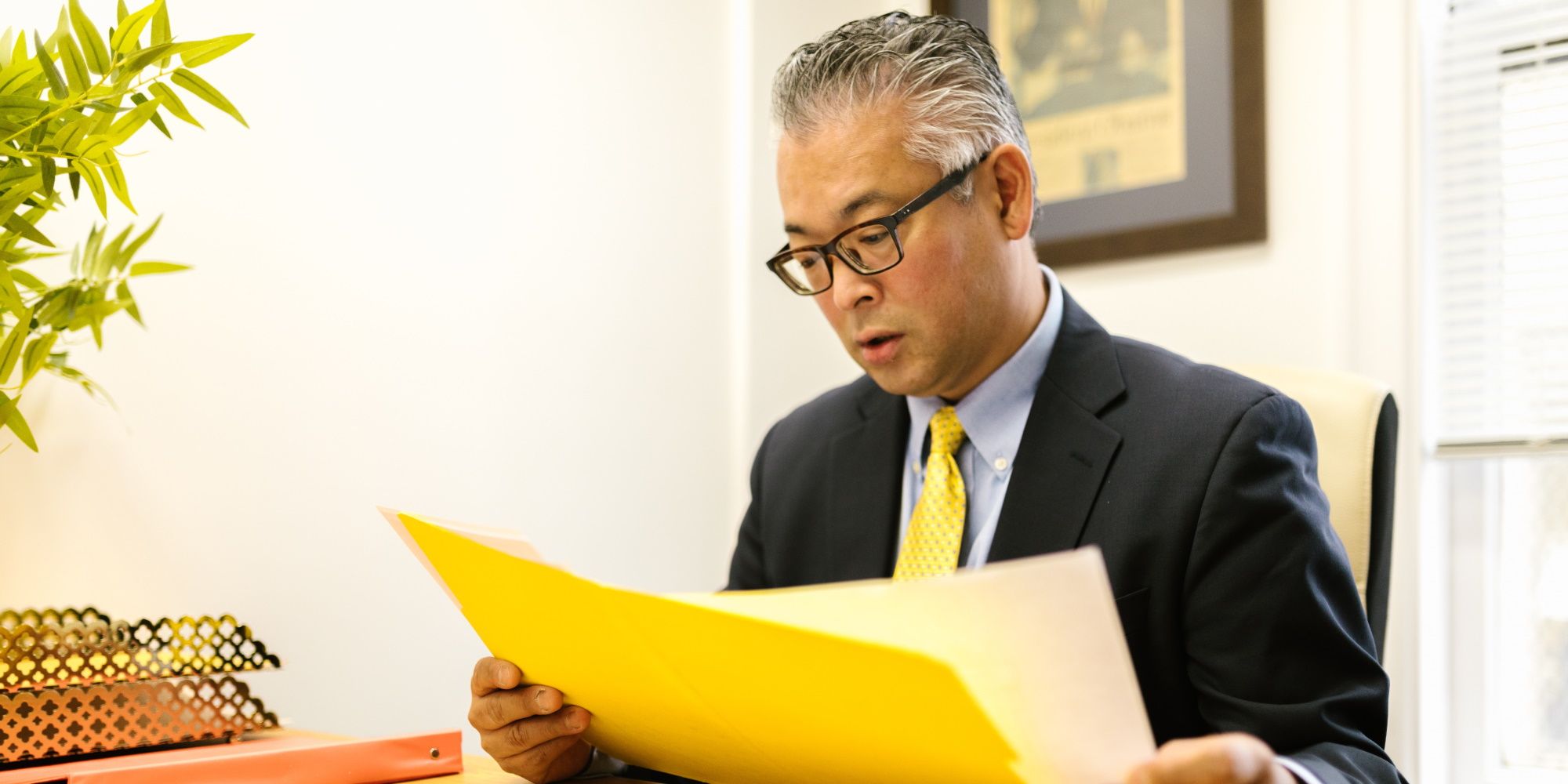 business man reading a document in yellow folder