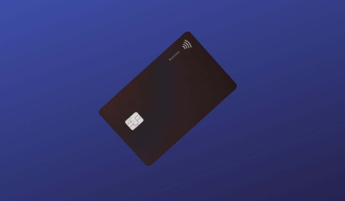 Black credit card seen on dark blue background