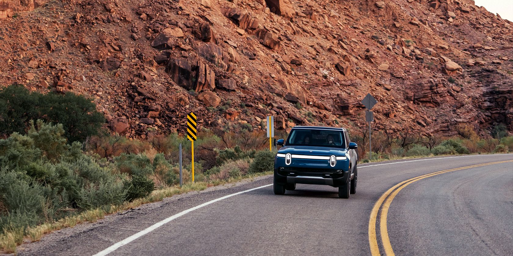 Rivian R1S driving in a canyon
