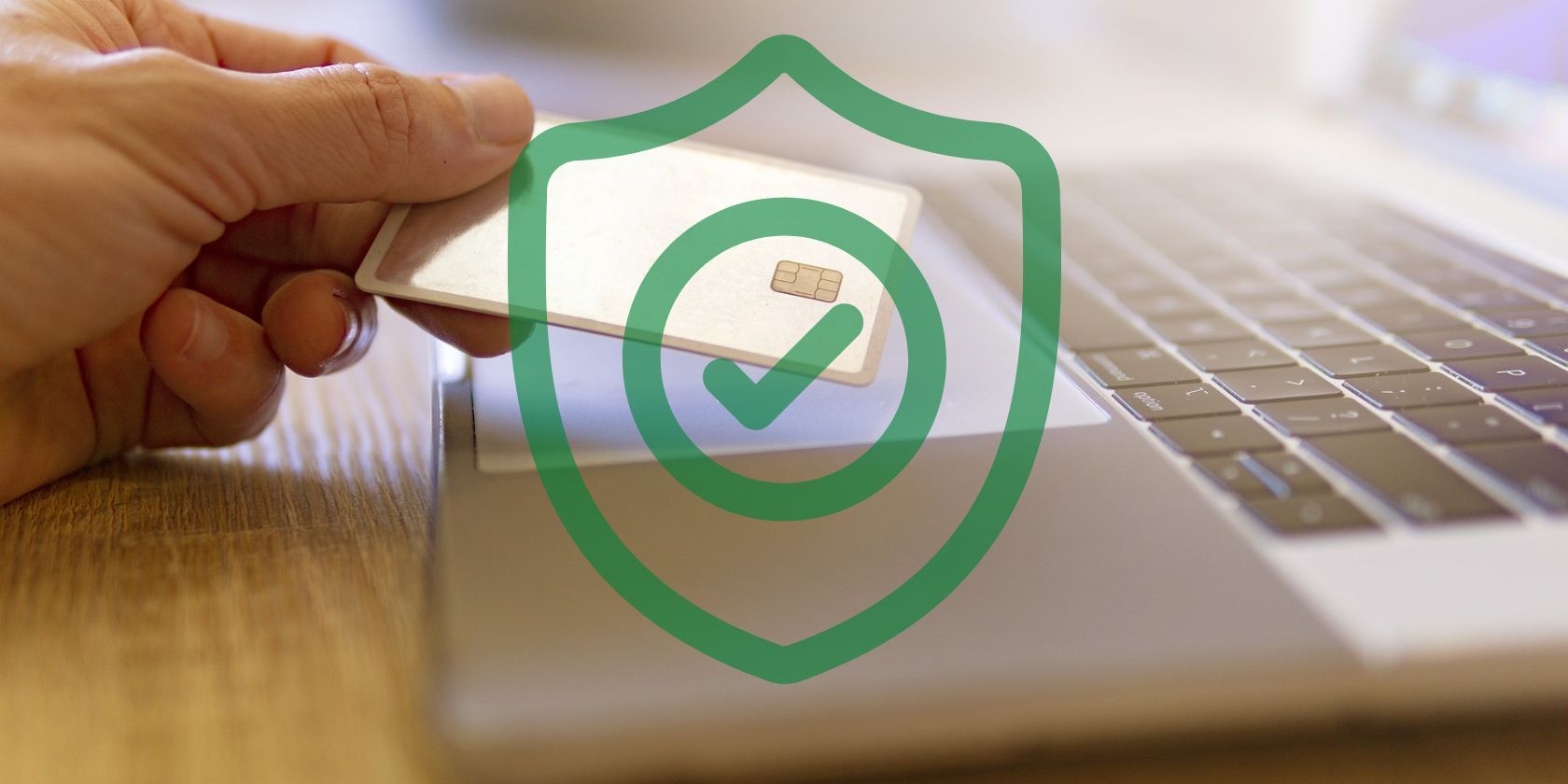Security symbol seen over a photo of a man holding a credit card next to a laptop