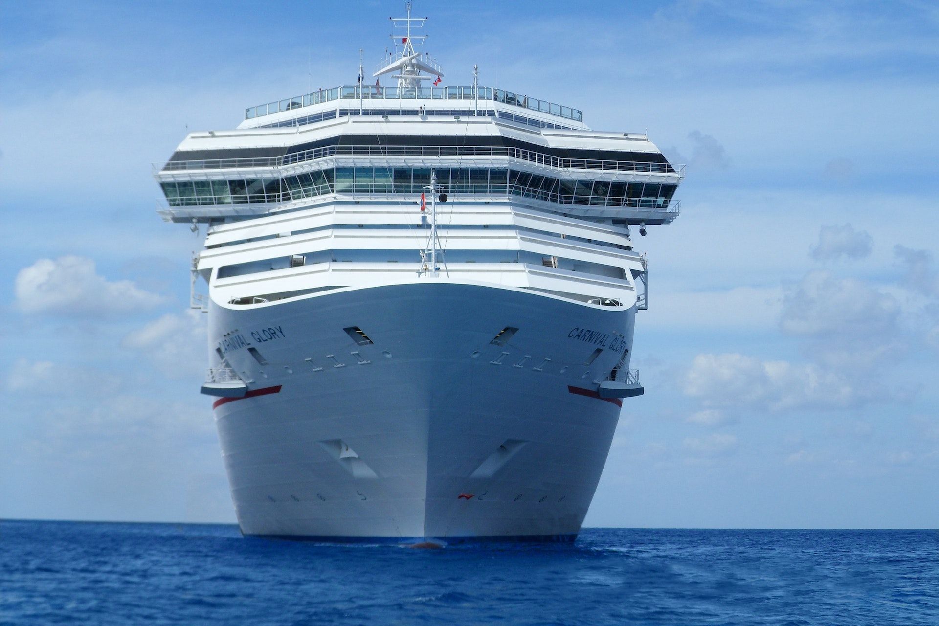 a white cruise ship on a blue sea against a blue sky