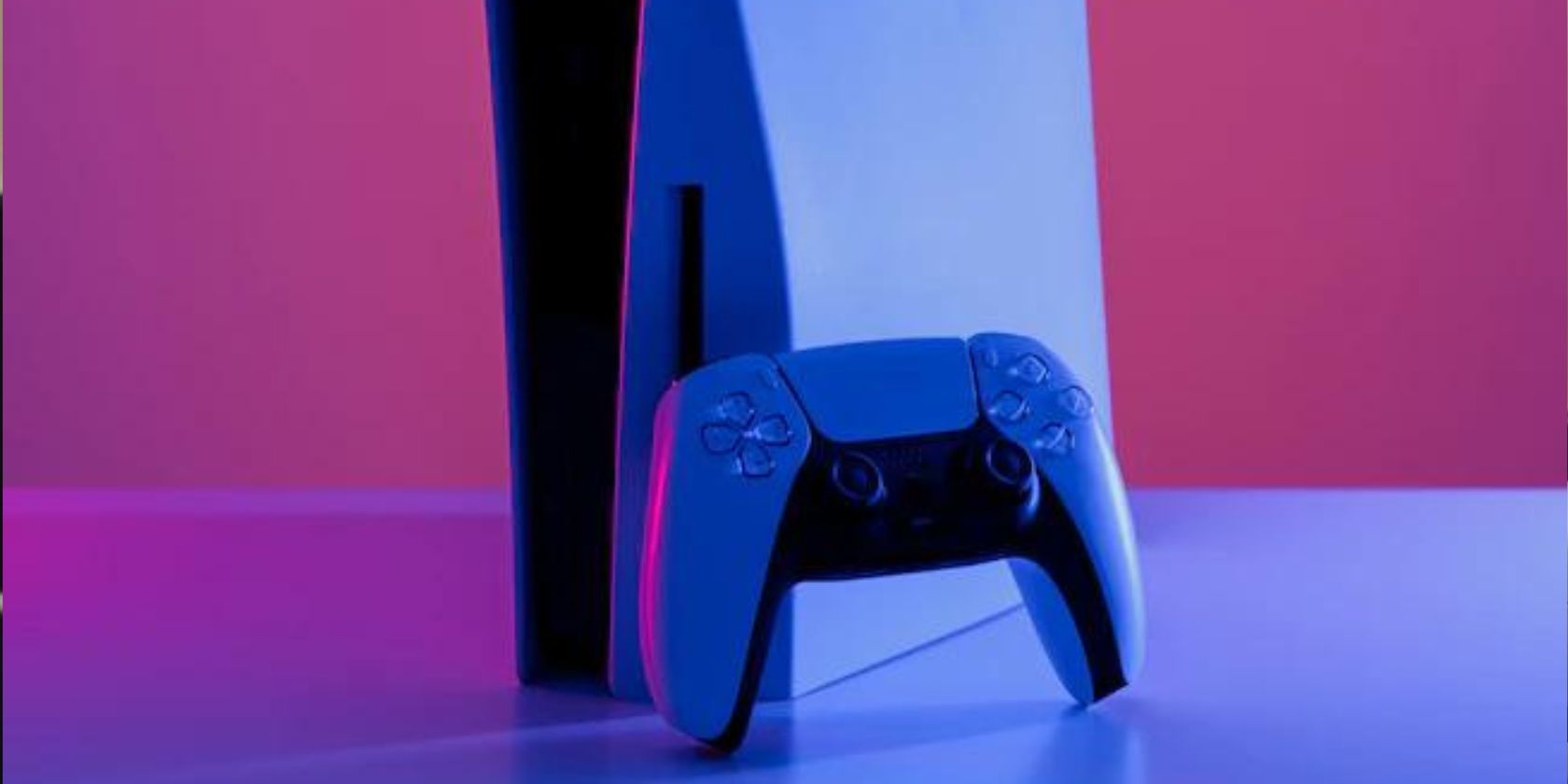 A DualSense controller leaning against PS5 console and pink and purple lighting