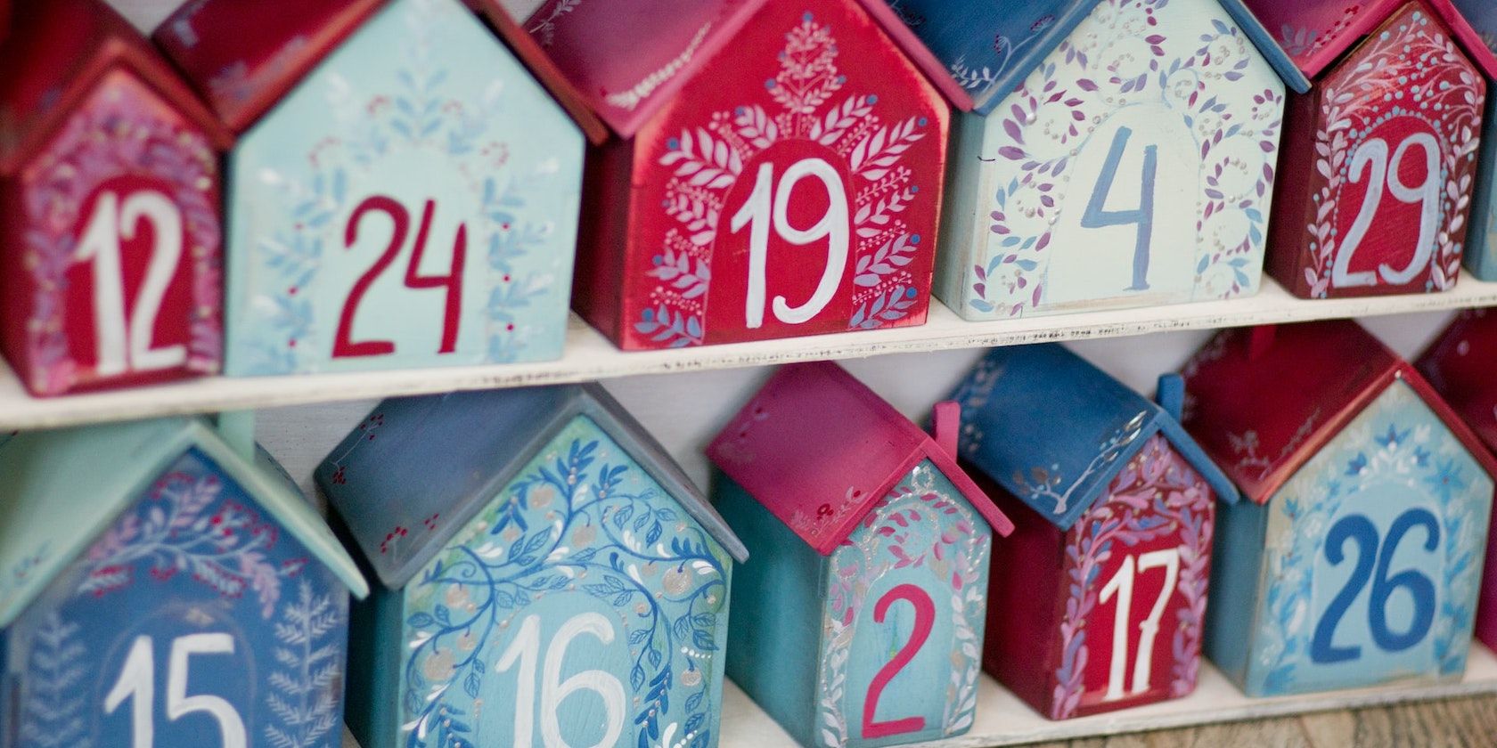An advent calendar made of numbered wooden boxes painted red and blue.
