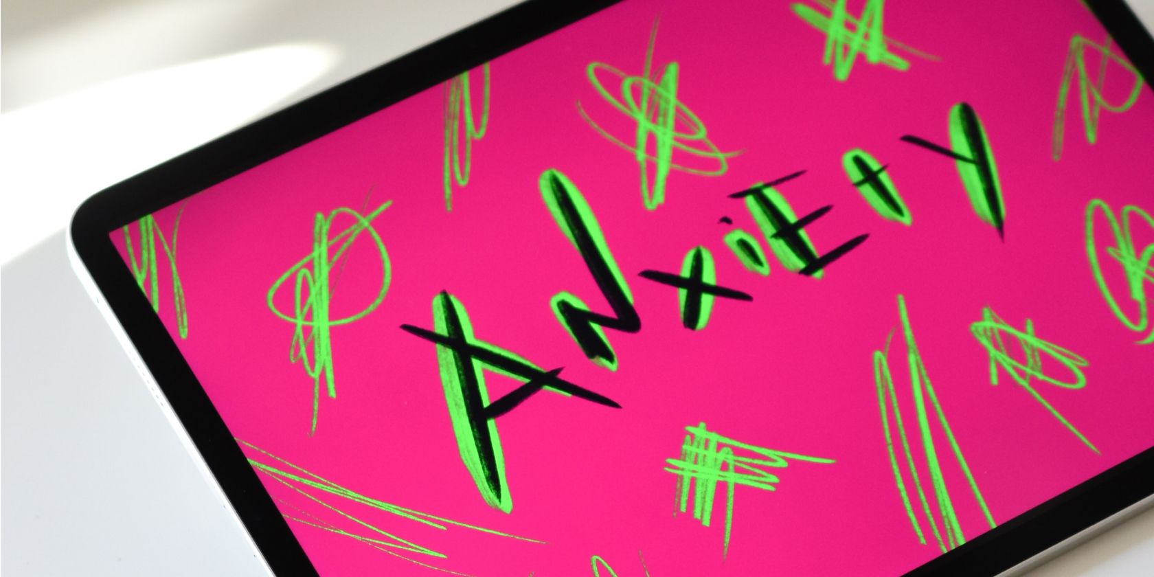 Anxiety word sketched with a pink background in an iPad