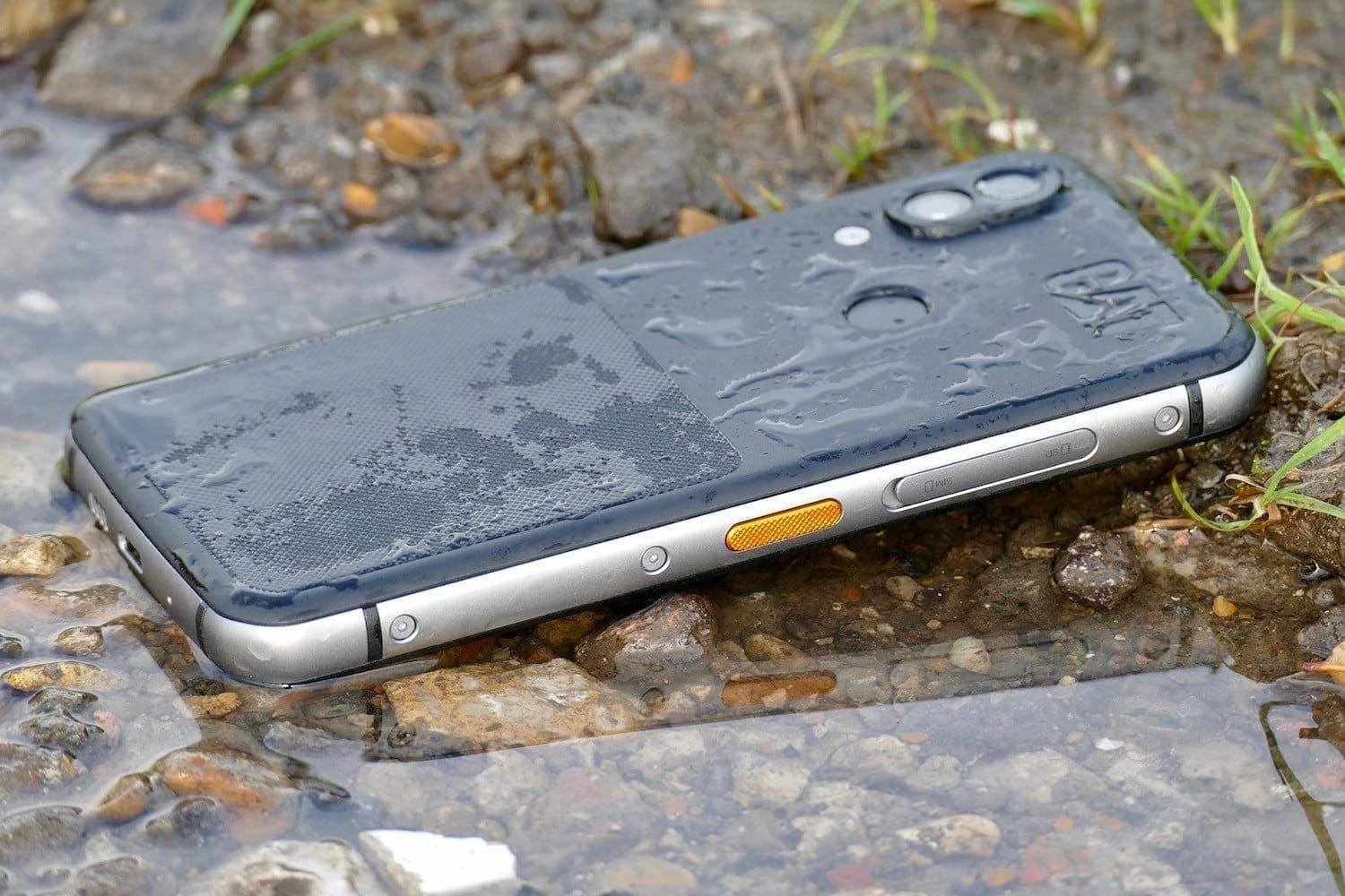 Cat S62 Pro، یک گوشی هوشمند ناهموار، روی زمینی از شن و خاک پوشیده از آب