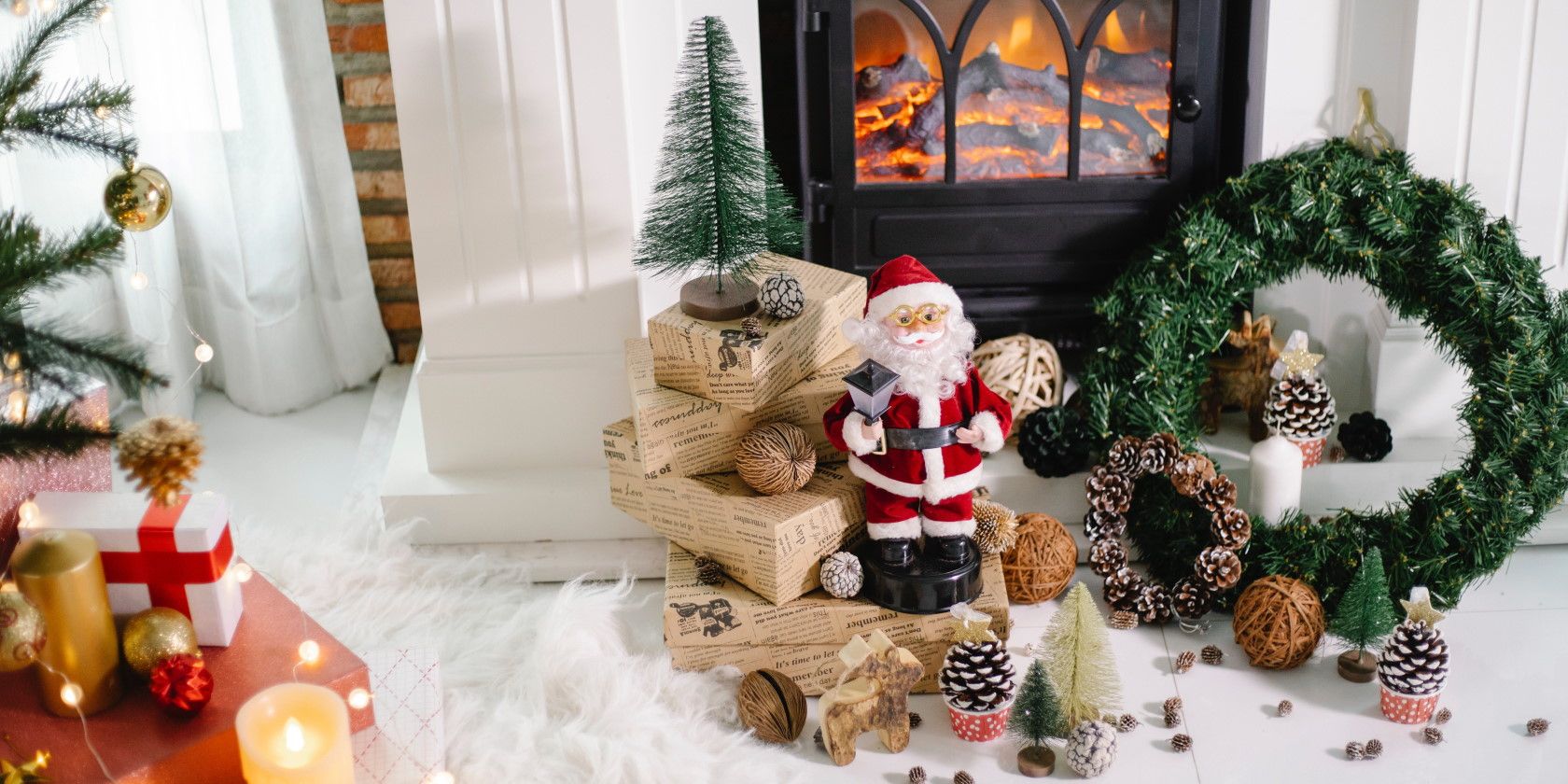 Décorations de Noël et jouets installés devant une cheminée allumée