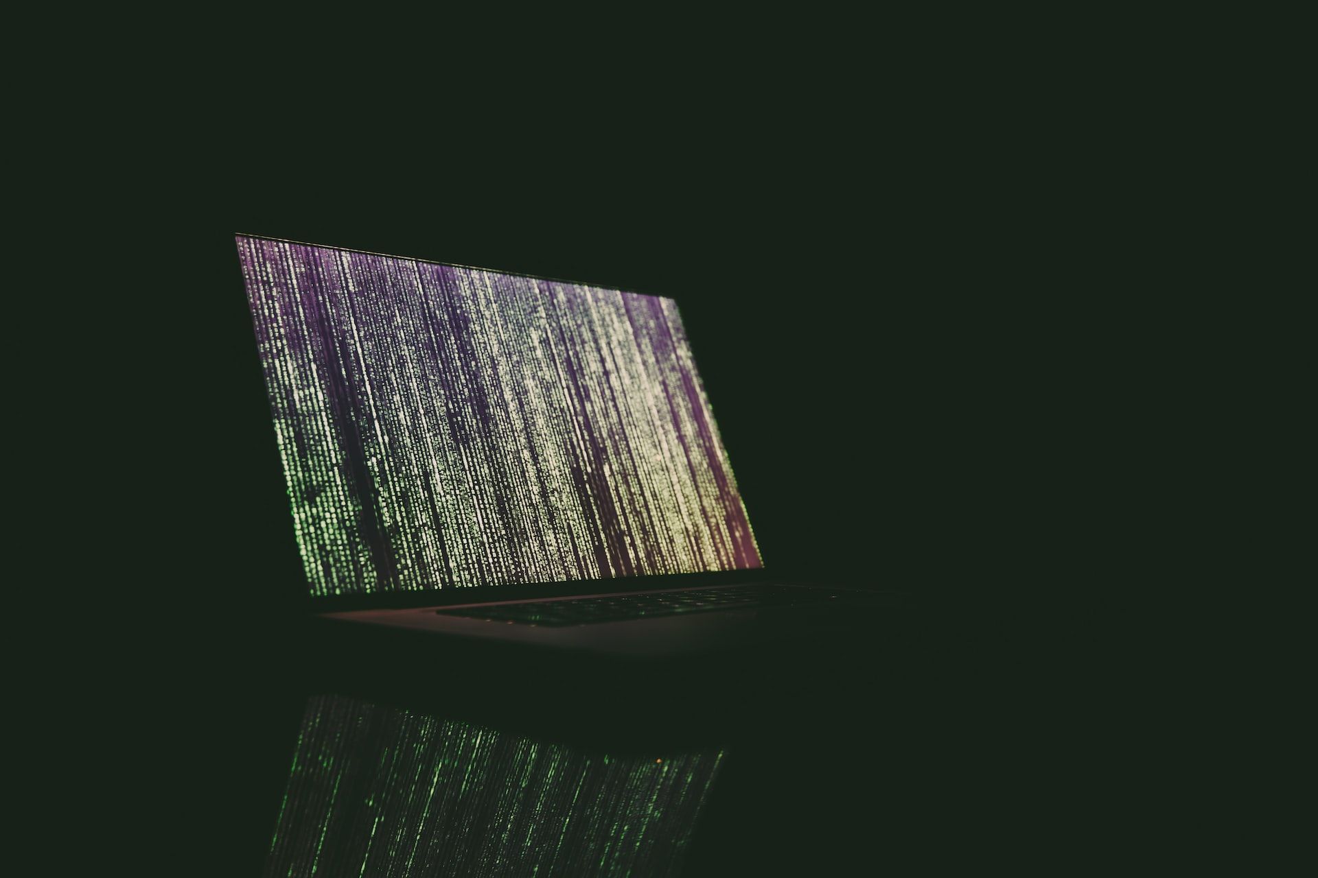 Image of a computer with green code