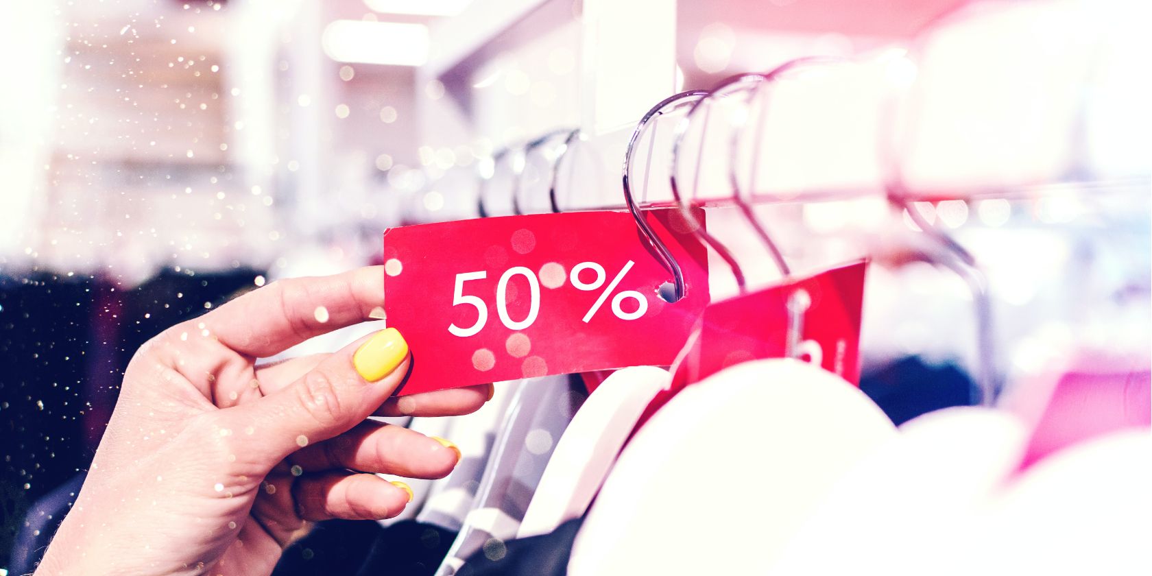 A lady holding a discount price tag on a hanger in a store