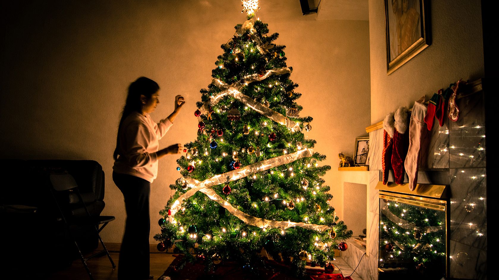 دختری که درخت کریسمس را تزئین می کند