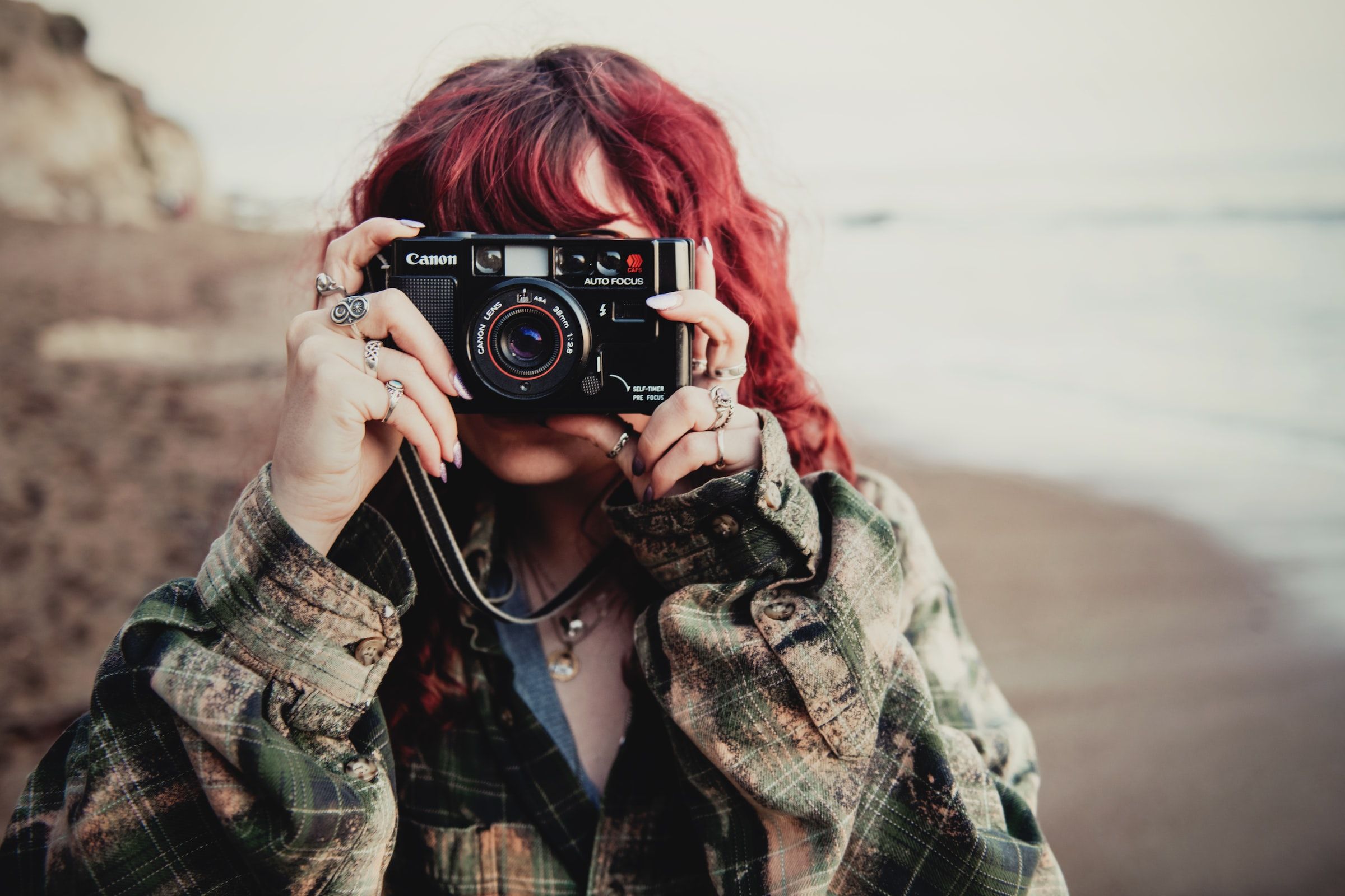 girl with red hair shooting on a vintage canon film camera with 38mm lens