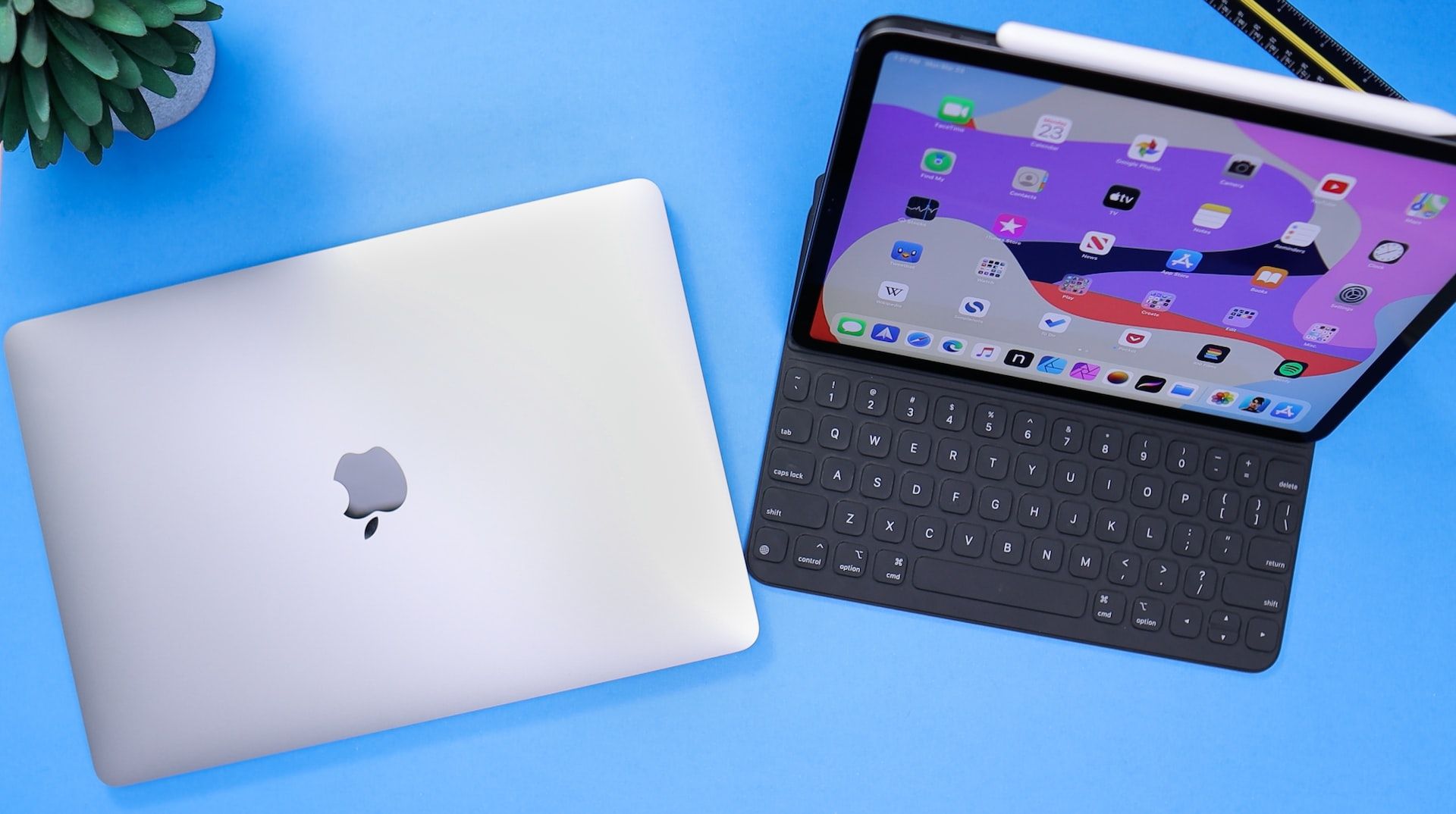 iPad and a closed MacBook on a blue background