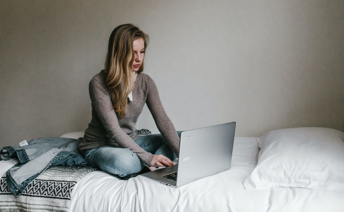 A woman using her laptop on her bed