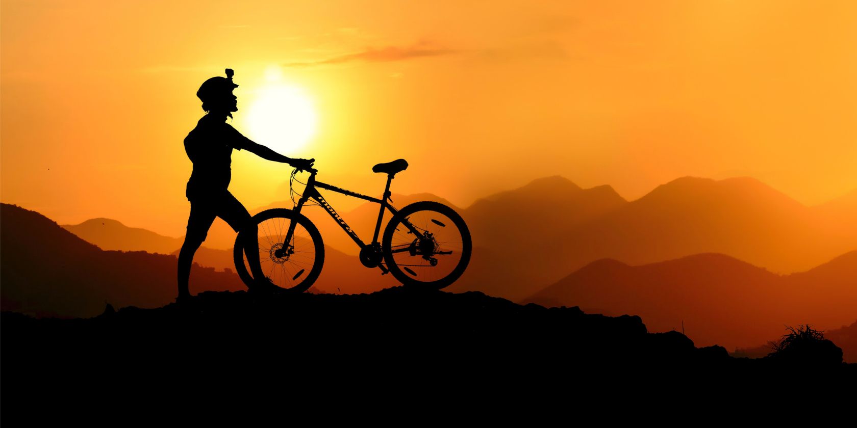 Side view of mountain biker on a mountain at sunset