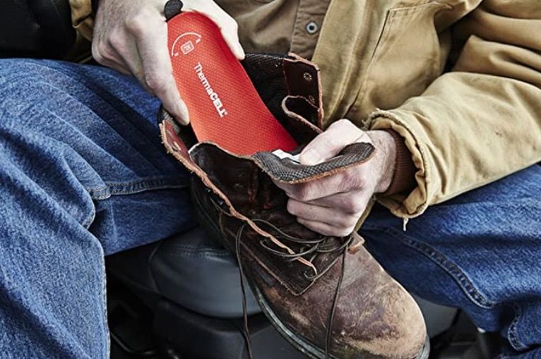 Man putting a heated insole in his boot