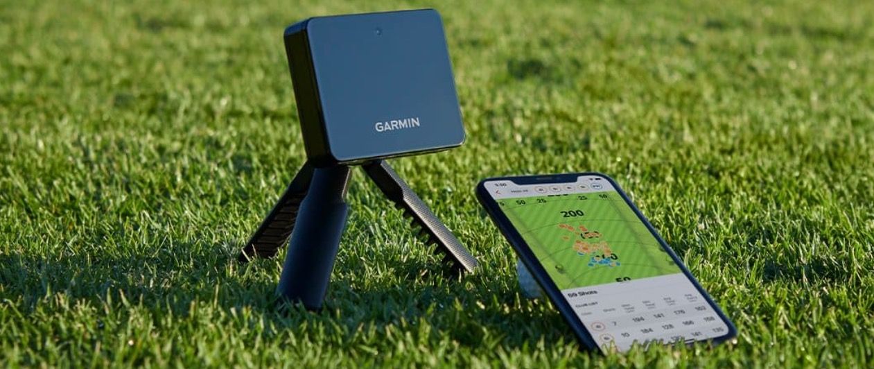 Launch monitor on grass next to smartphone