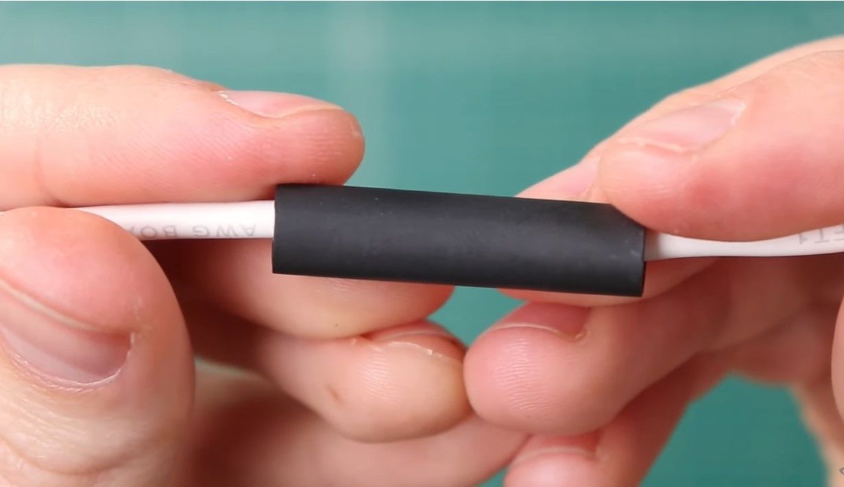 Black shrink tubing covering a cable