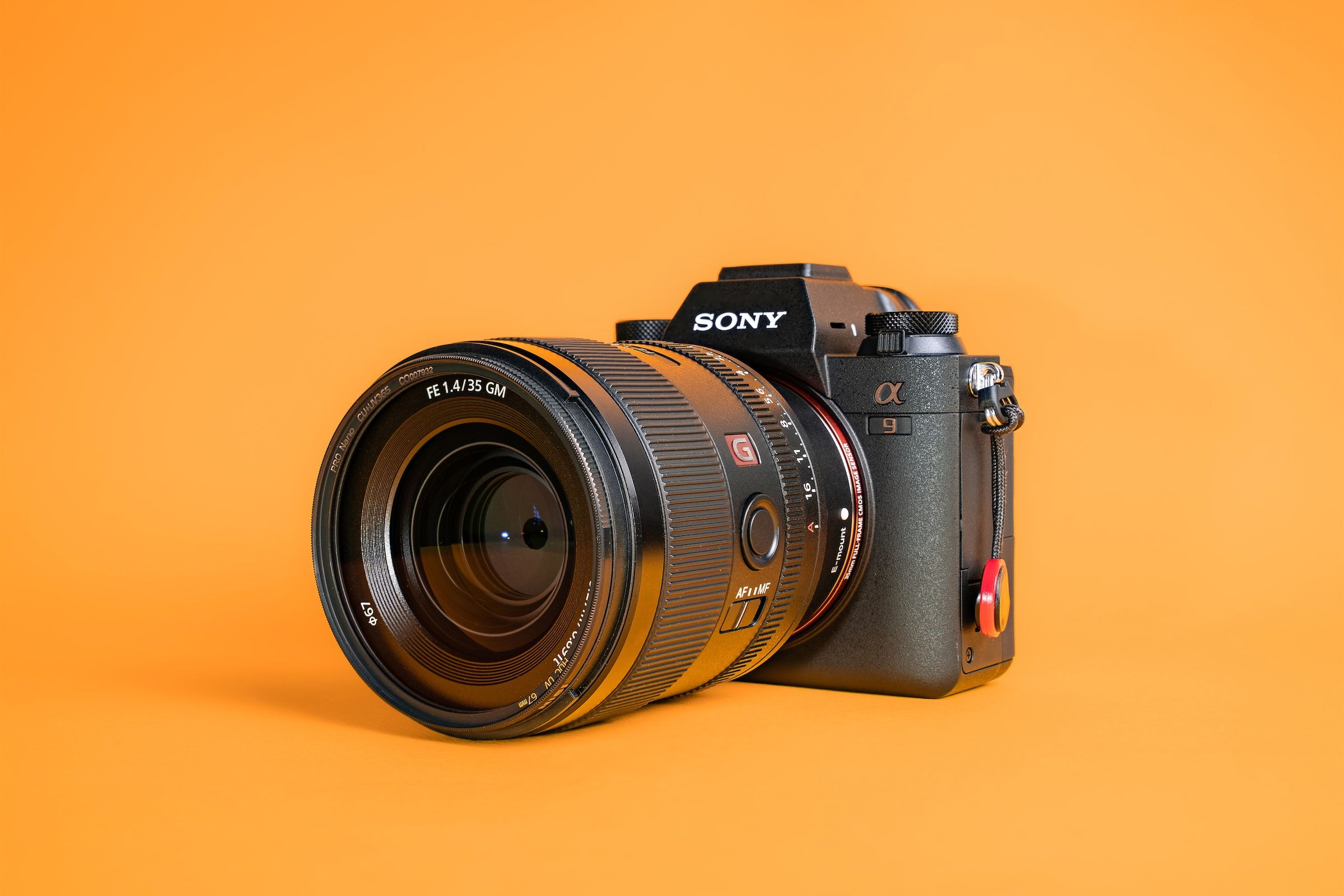 sony a9 mirrorless camera on orange background with 35mm f/1.4 fe g master lens