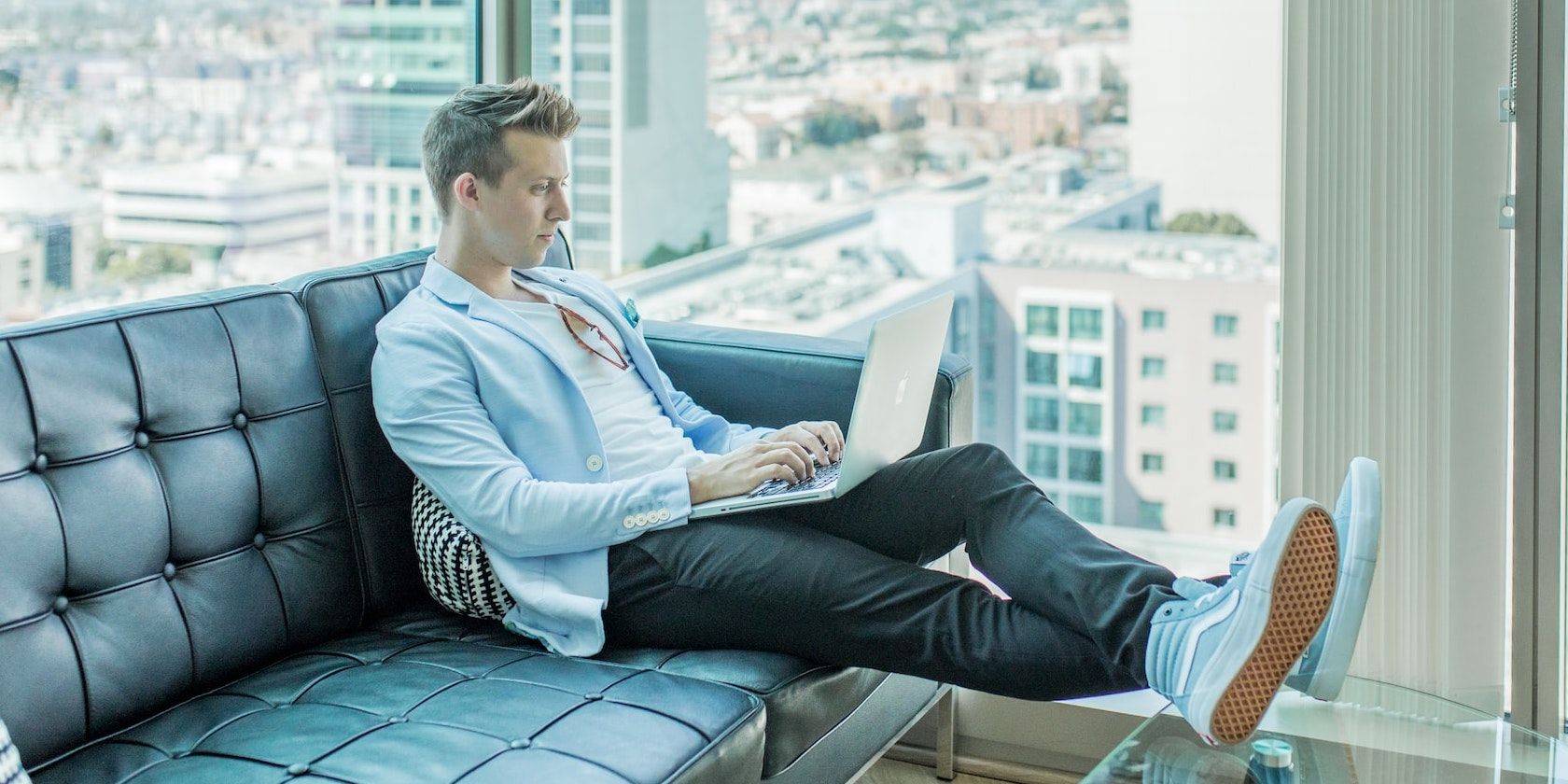 Man Working on Computer in Glass House