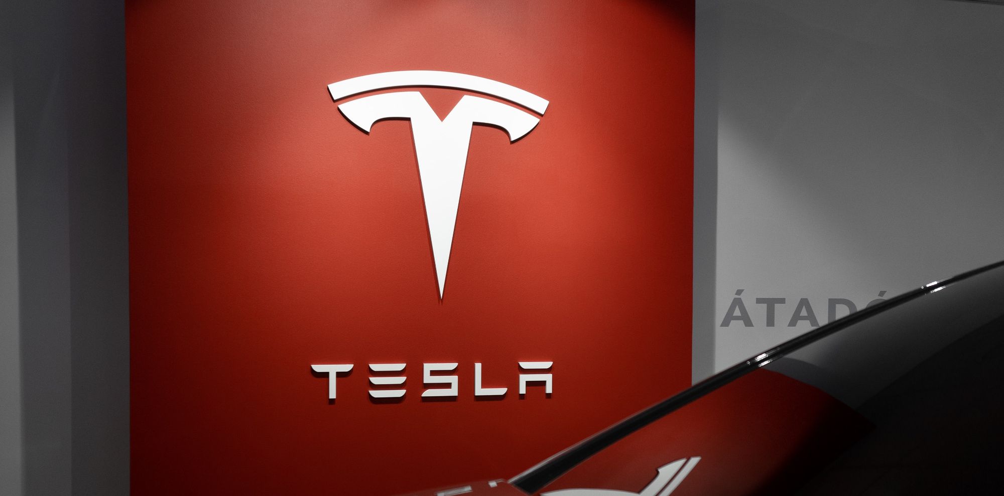 Photo of a red billboard with the Tesla logo