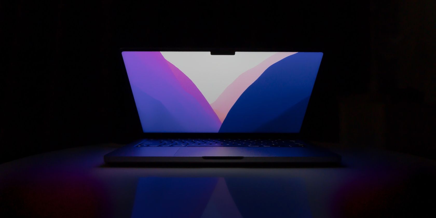 14-inch MacBook Pro on a table in the dark
