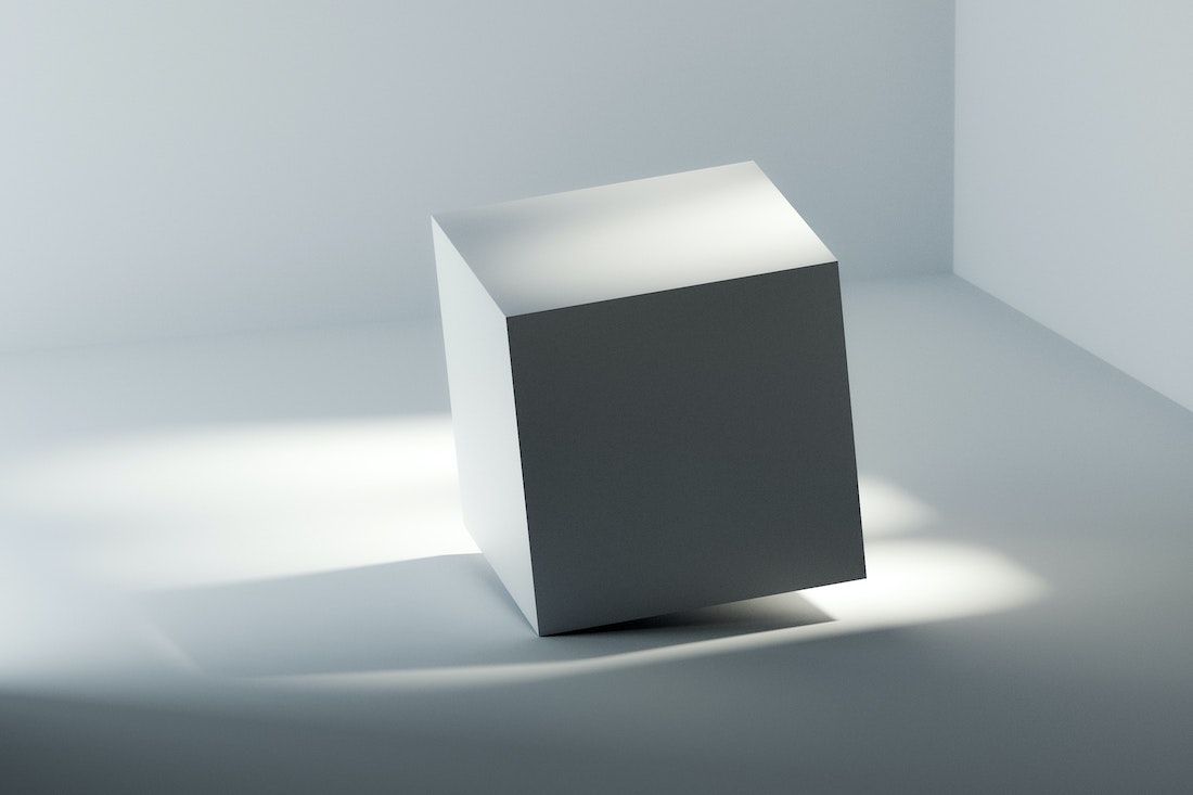 a tilted white cube under studio lighting
