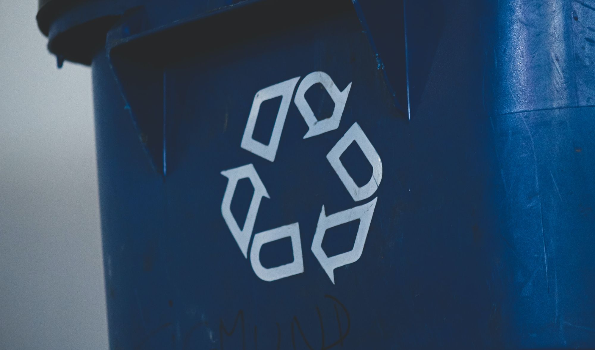 close up shot of blue bin with recycle icon on front