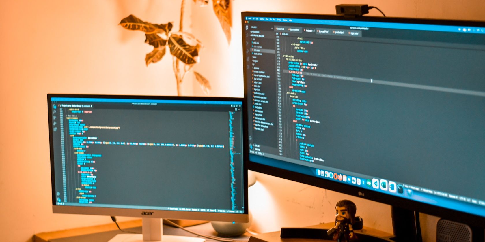 Two monitors side by side, one large and one small, each displaying code in a text editor