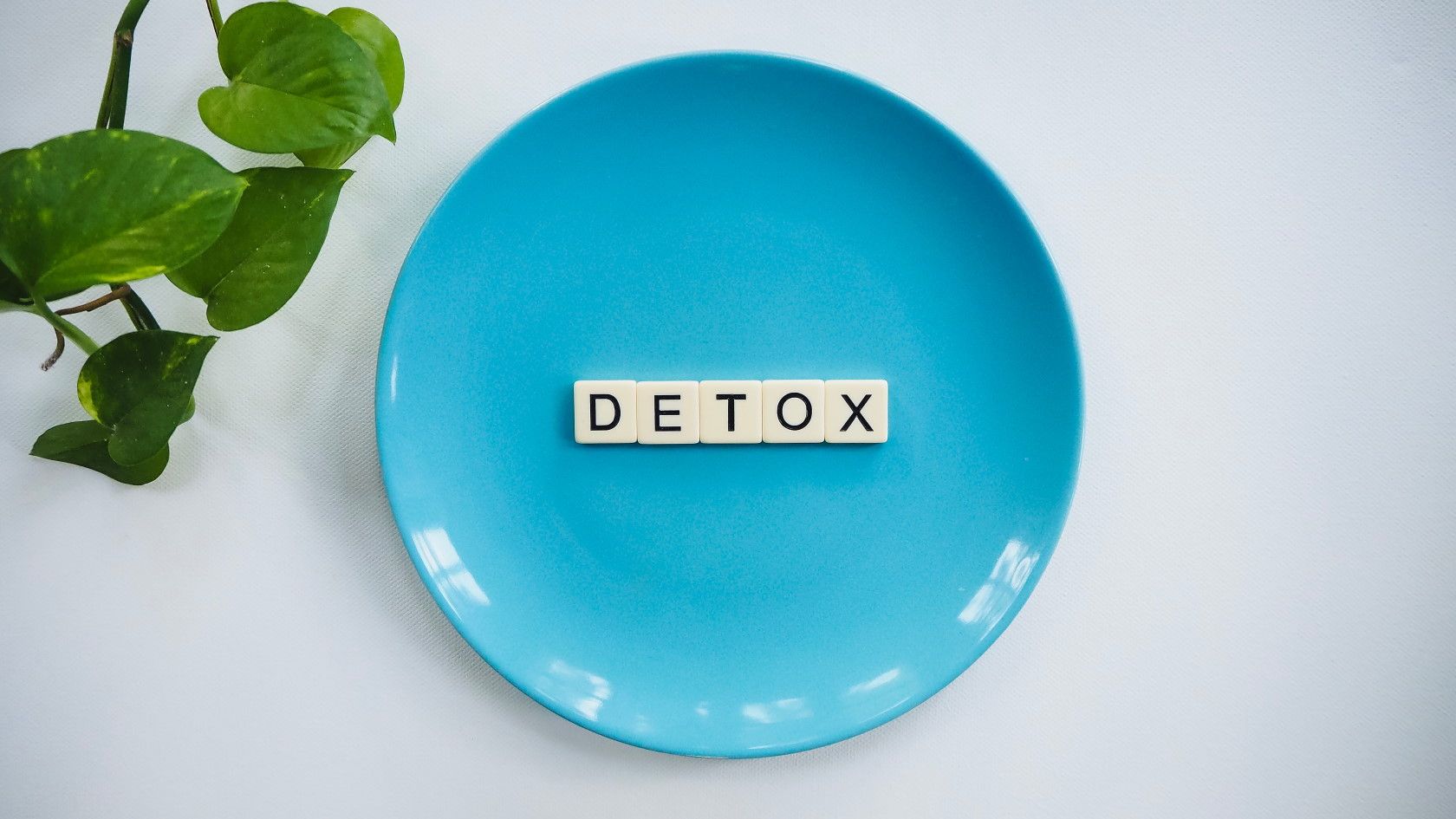 Blue plate on table with letters spelling word Detox