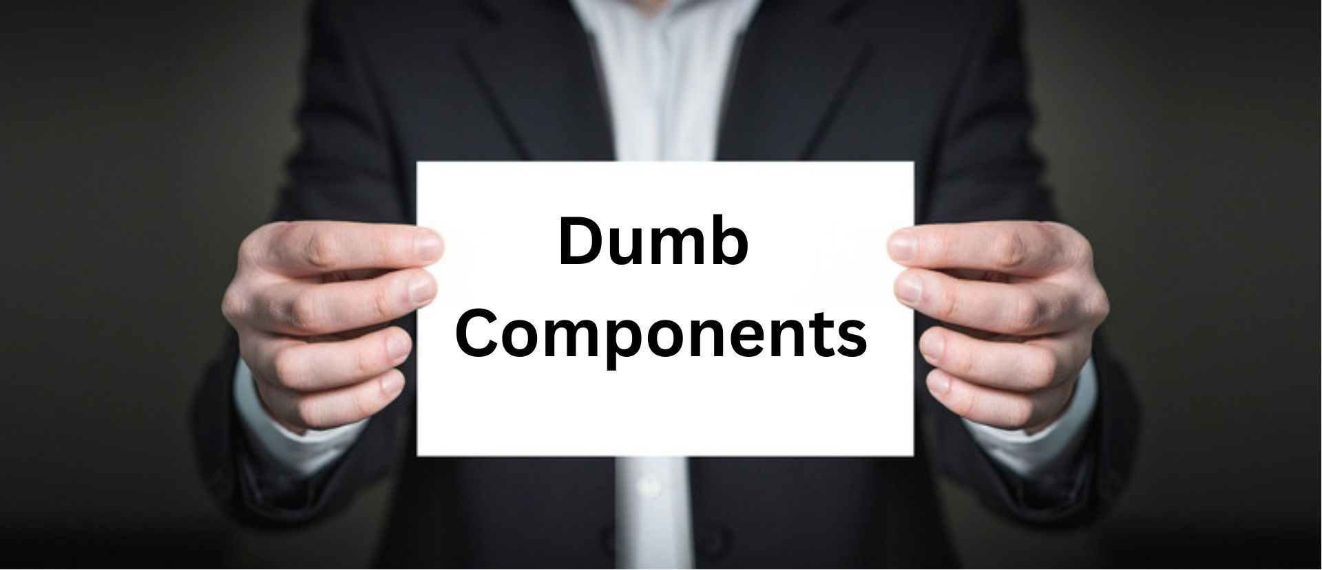 Một người đàn ông cầm tấm thẻ ghi Dumb Components