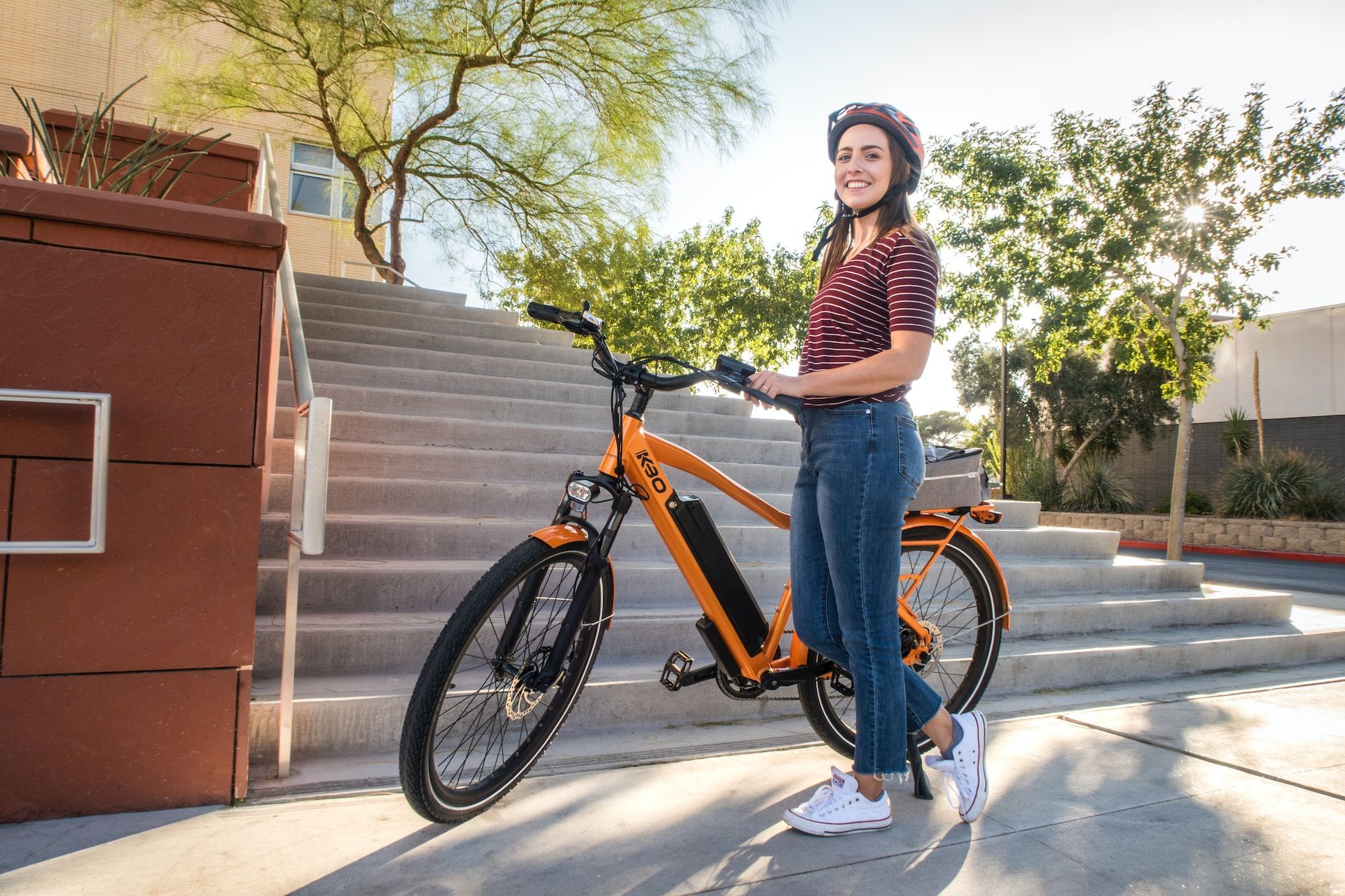 Personne debout à côté d'une bicyclette électrique orange