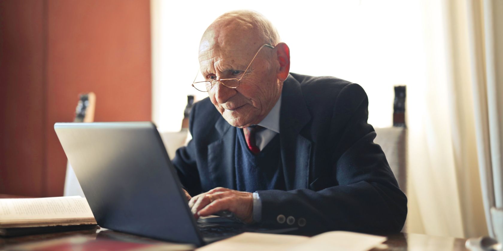 Elderly Man with Glasses on Black Laptop