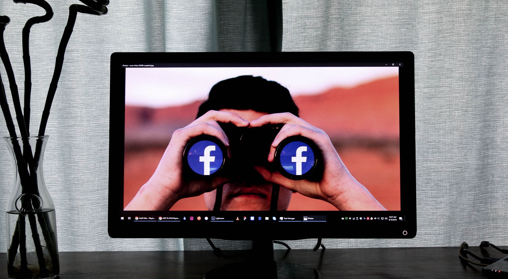 foto de computadora de un hombre mirando a través de binoculares cubierto con el logo de facebook