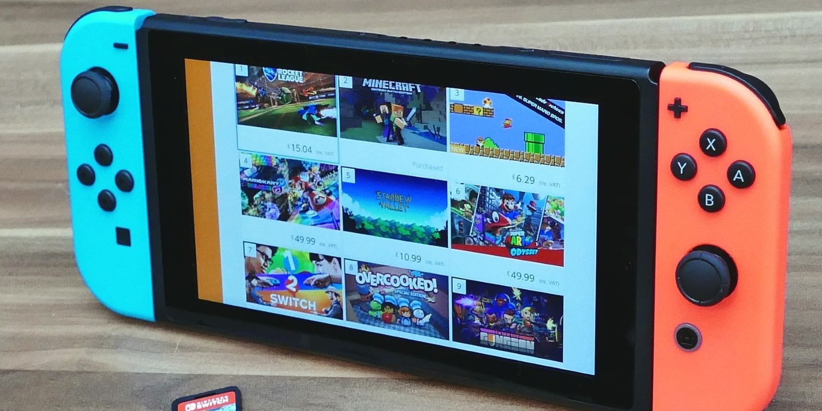 A photograph of a Nintendo Switch console with red and blue Joy Cons and Games and Apps displayed on screen