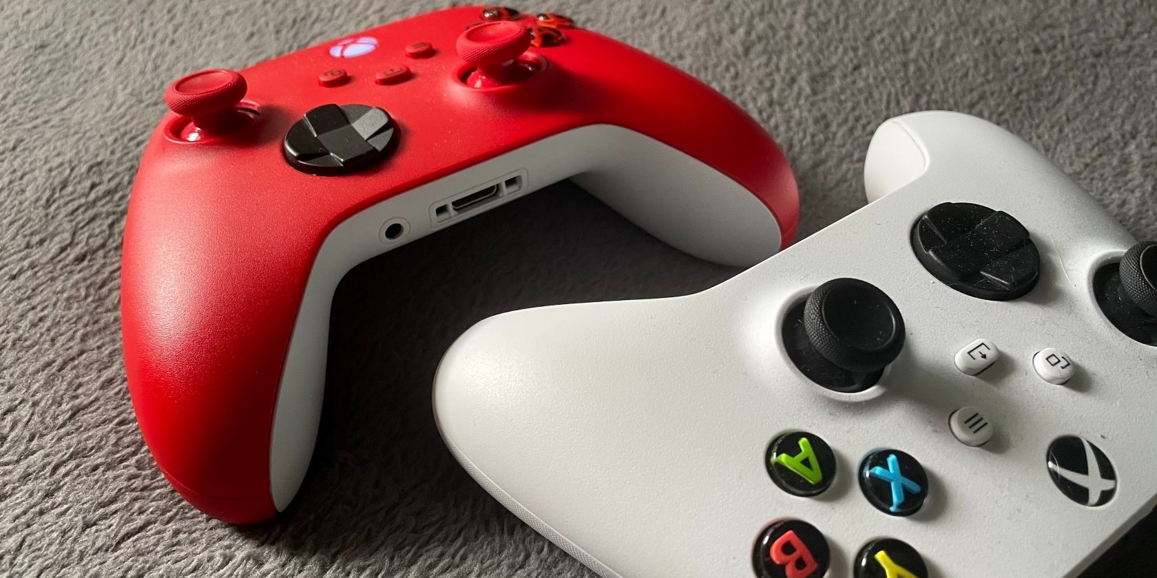 A photo of a red Xbox Series X controller next to a standard Xbox Series S controller 