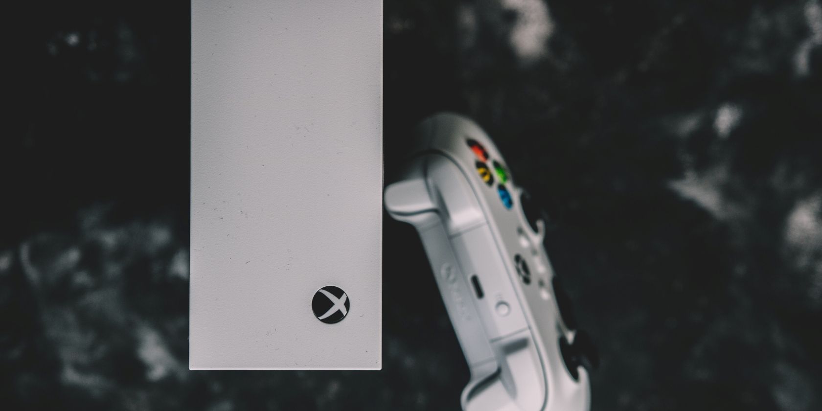 A photograph of an Xbox Series S next to an Xbox Series S controller 