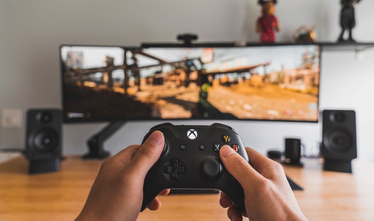 A photo of a black Xbox One controller in front of a screen being set up