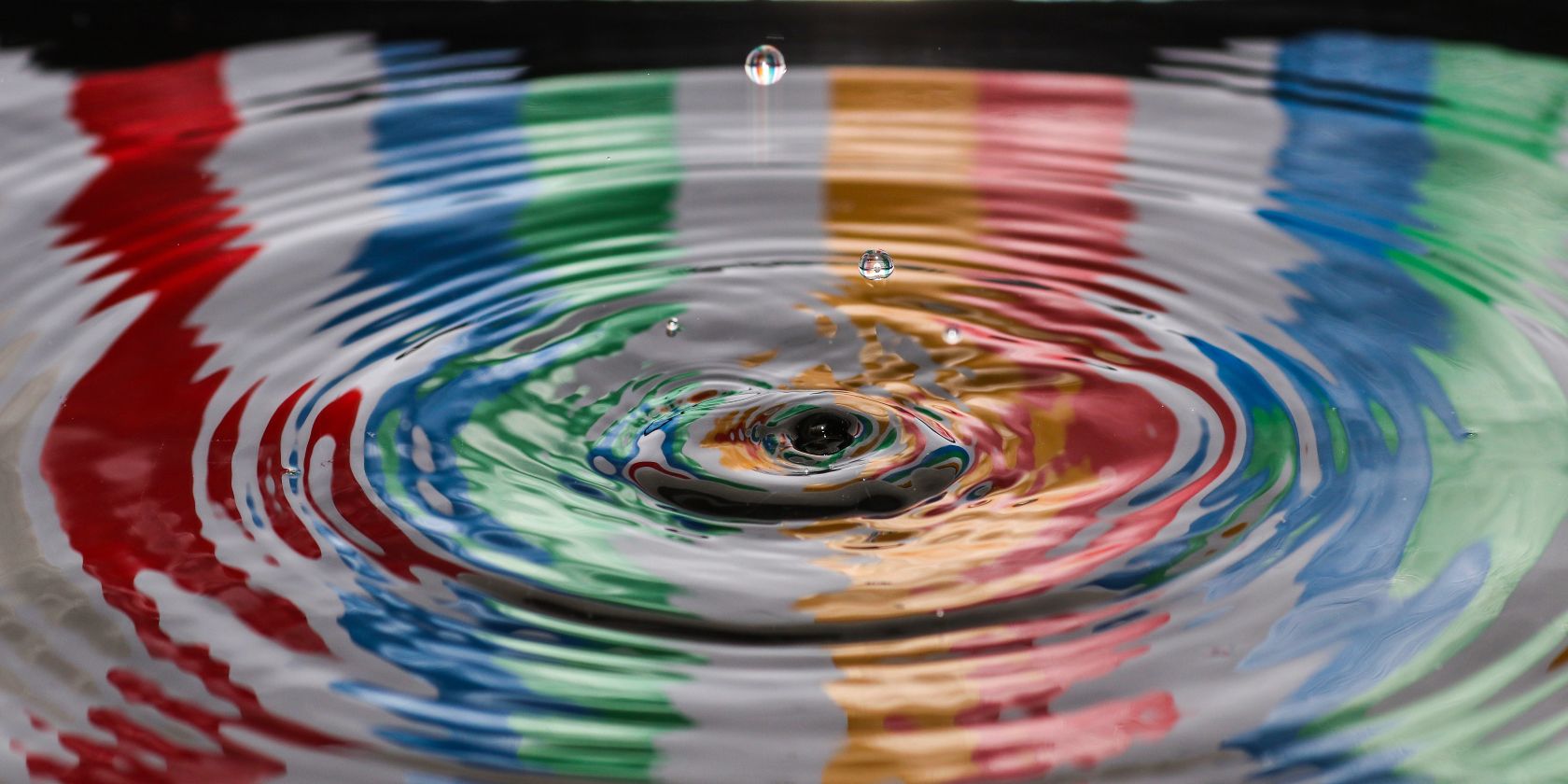 photo of water droplets with multiple colors in the background
