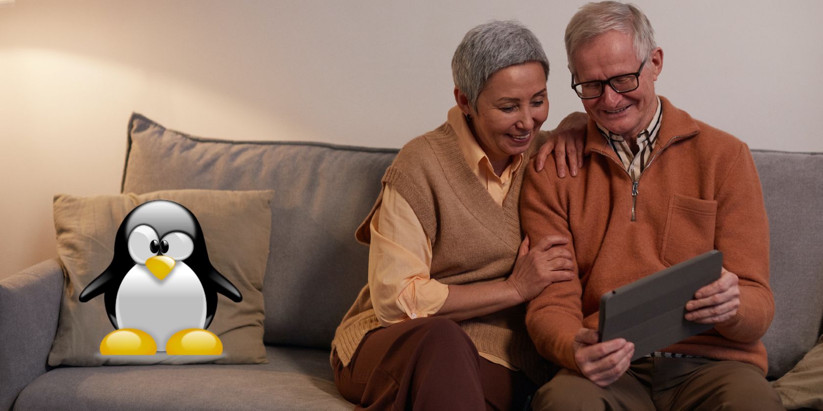 An elderly couple sitting on a sofa using a tablet