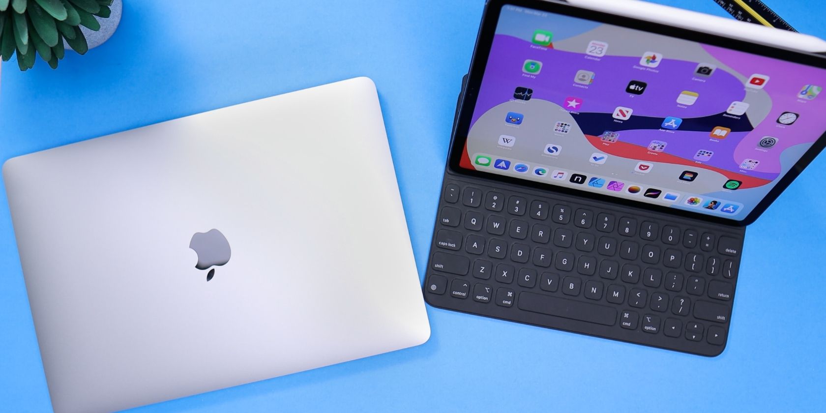 Un MacBook à côté d'un iPad sur un bureau