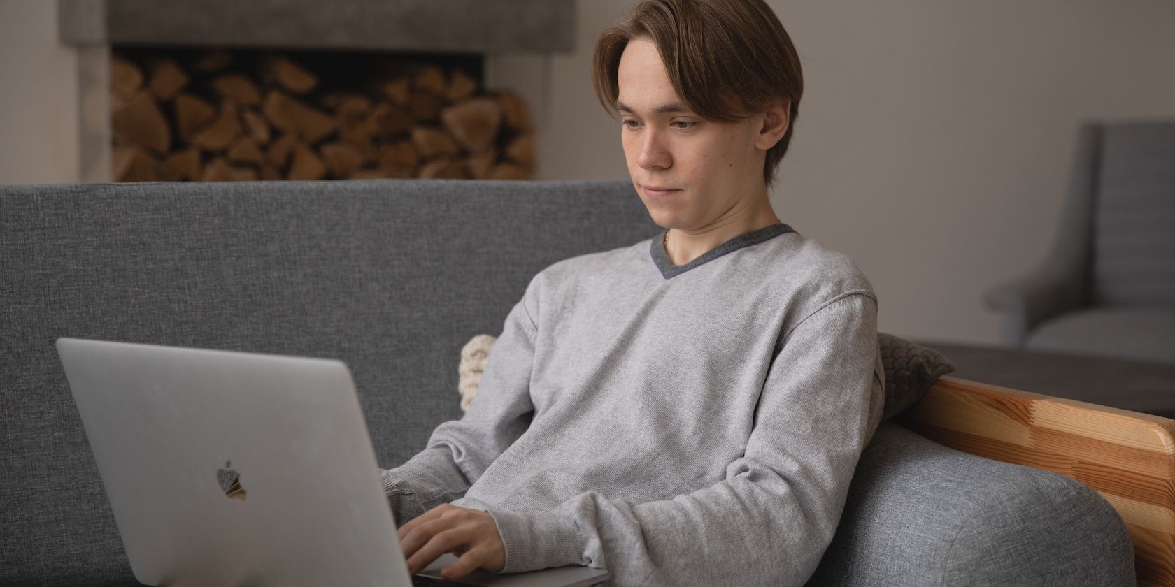 Homme utilisant un MacBook sur un canapé