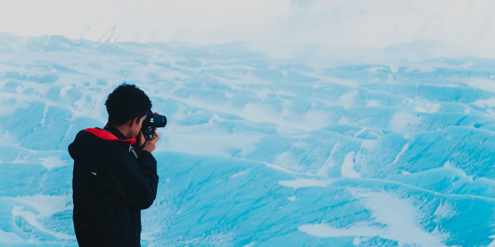 Photographer taking a picture of snowy mountains