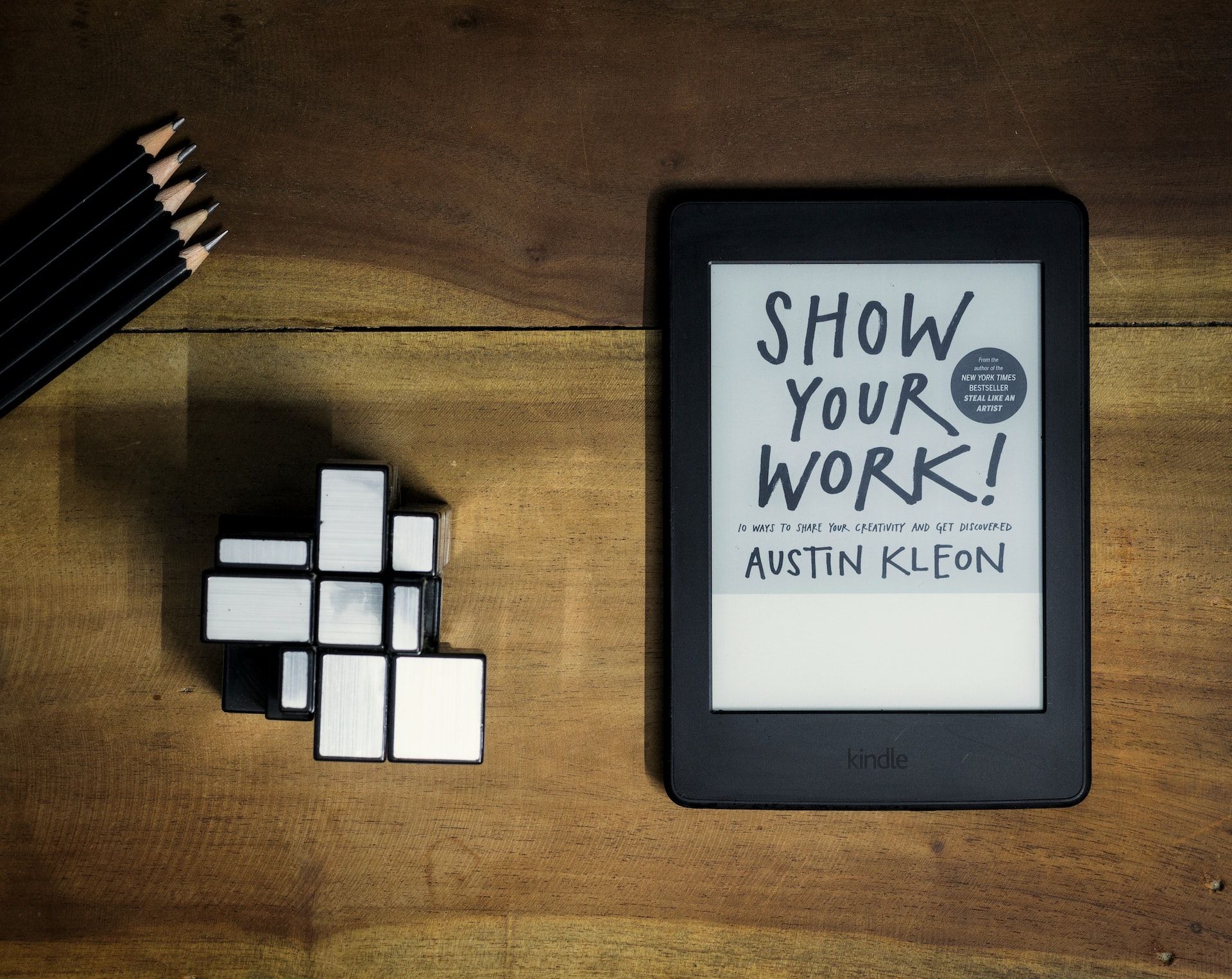 Amazon Kindle sur une table en bois avec l'option Show Your Work ouverte.