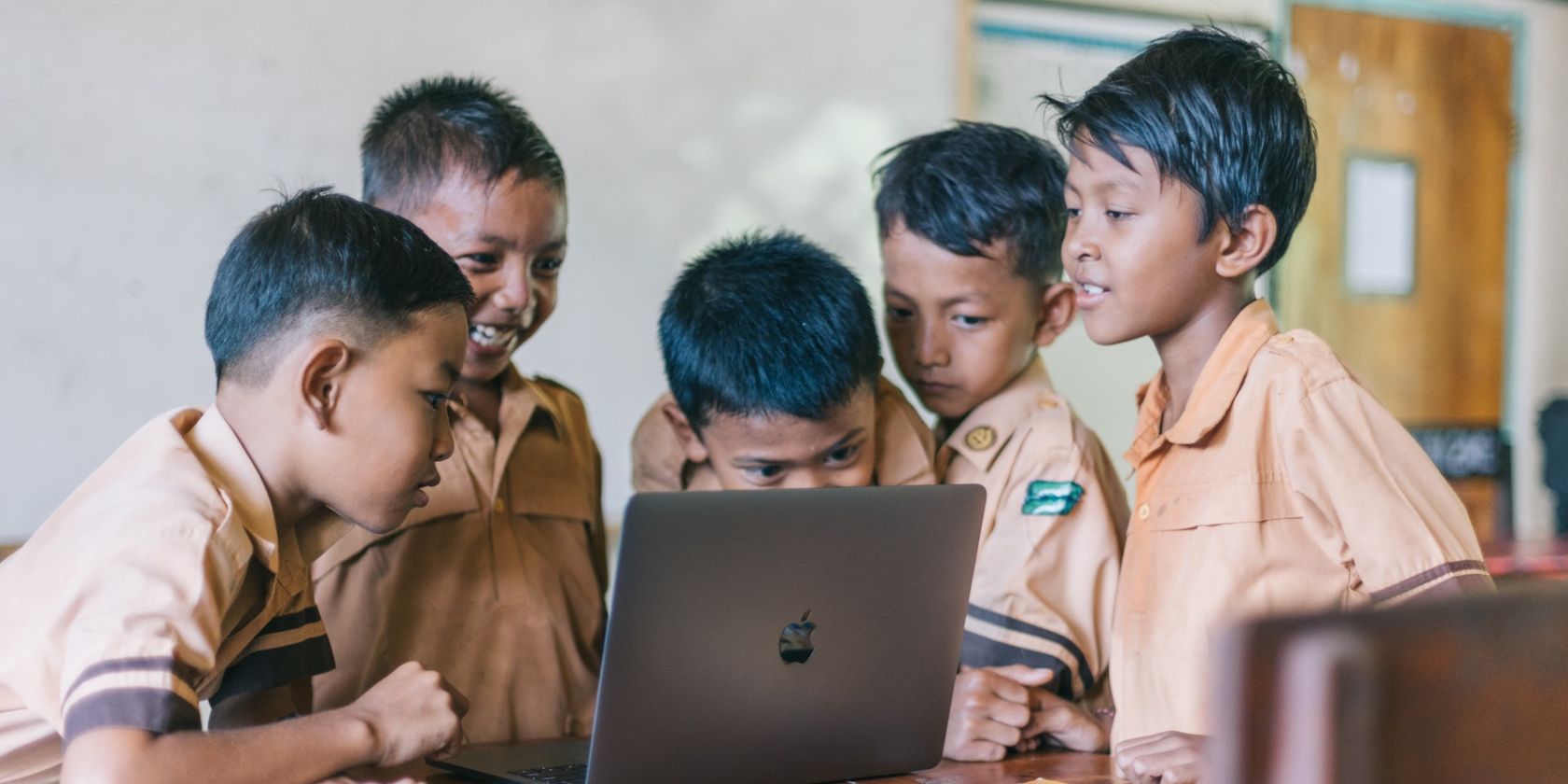 kids surrounding a laptop device