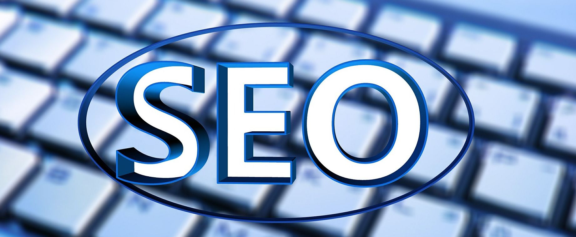 The word “SEO” in huge letters, superimposed on a blurry keyboard