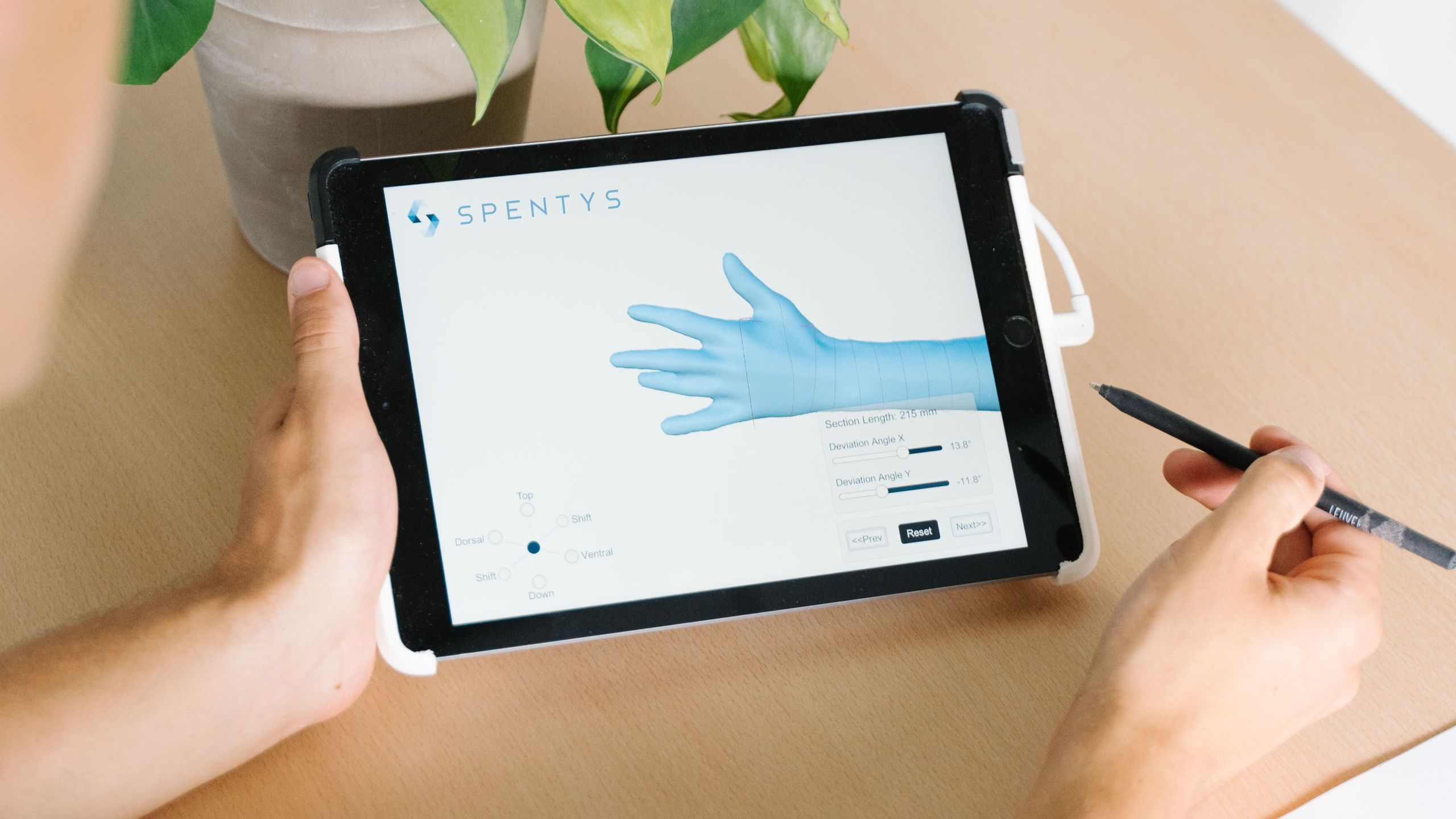 Person holding a tablet that shows 3D model of hand