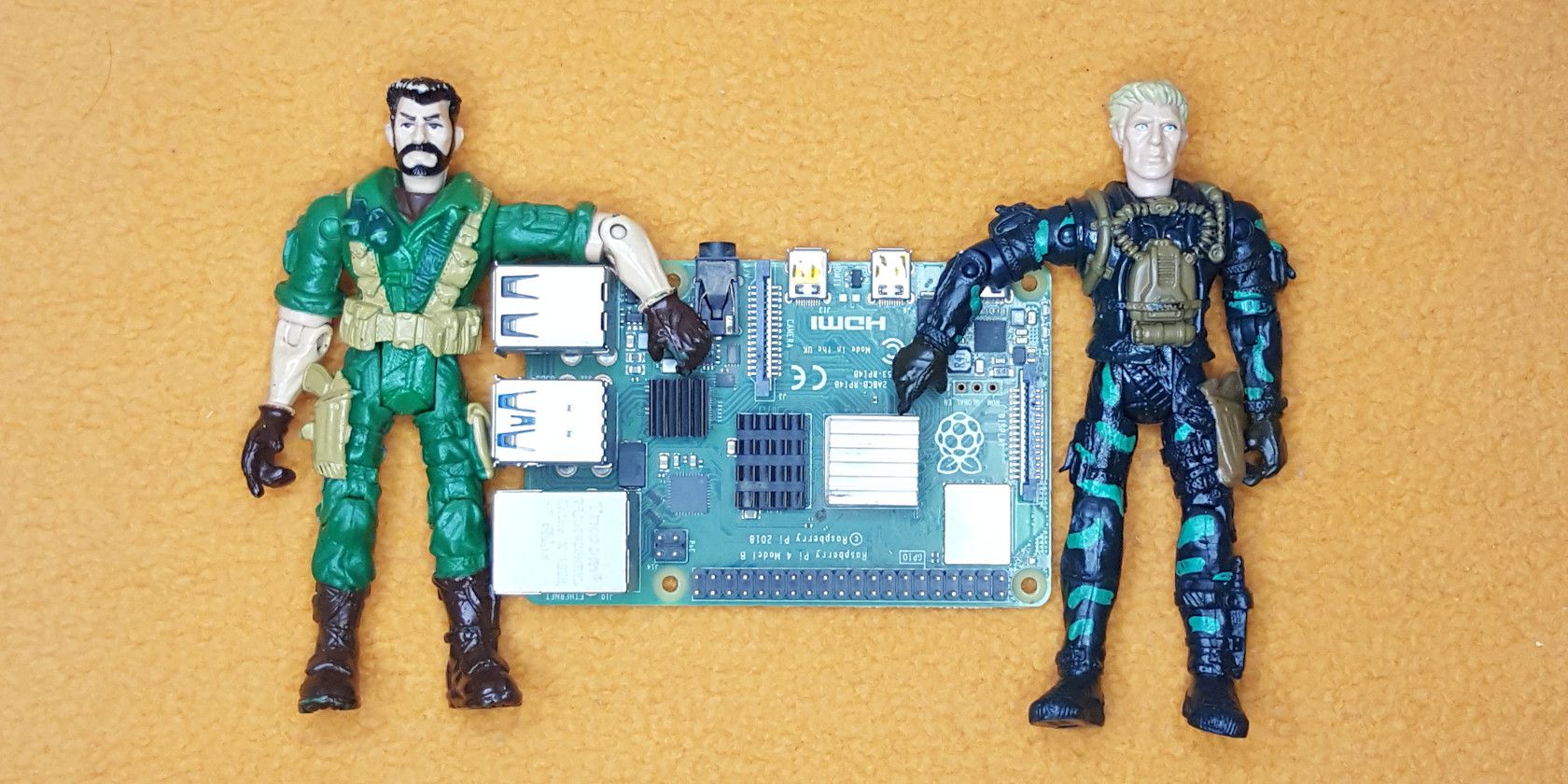 Two Toys Representing Users Holding A Raspberry Pi4
