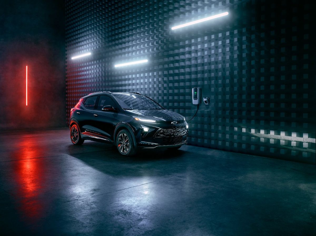 Chevy Bolt EUV 2023 đang sạc bên cạnh bức tường kết cấu có đèn trắng và đỏ