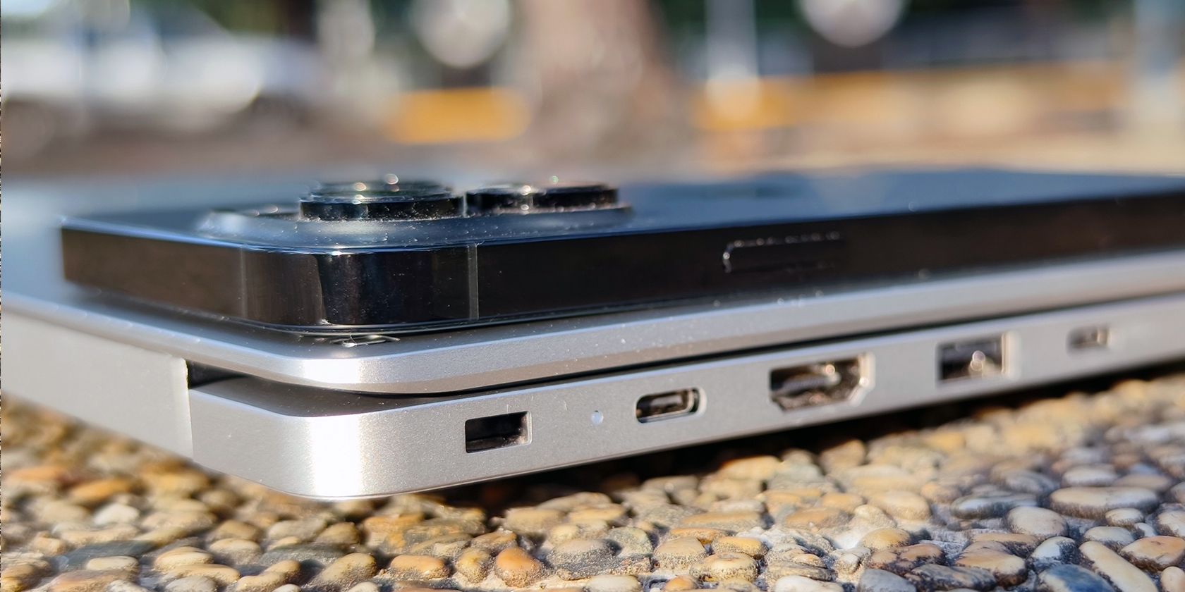 An iPhone 14 Pro Max placed on top of the Tecno Megabook T1 for thickness comparison
