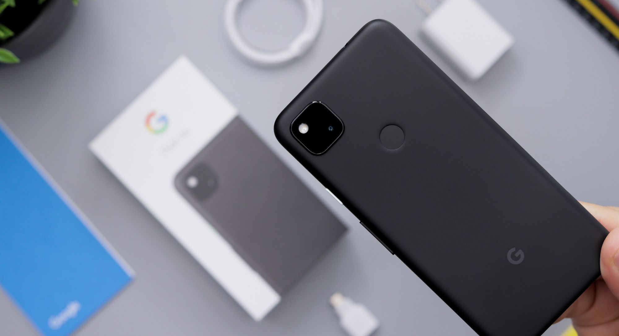 person holding black google pixel phone on top of exterior packaging
