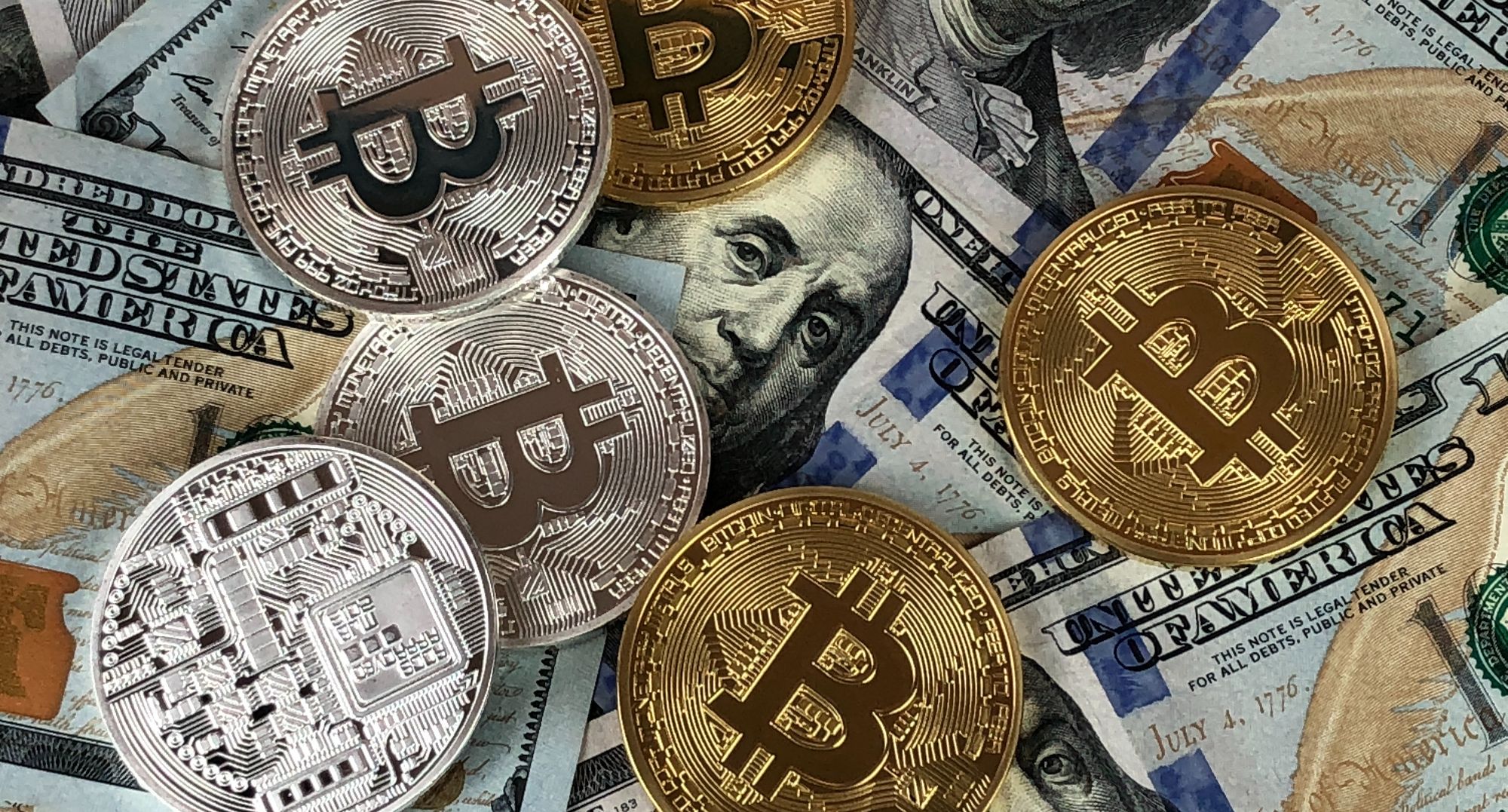 Bitcoin coins above US banknotes